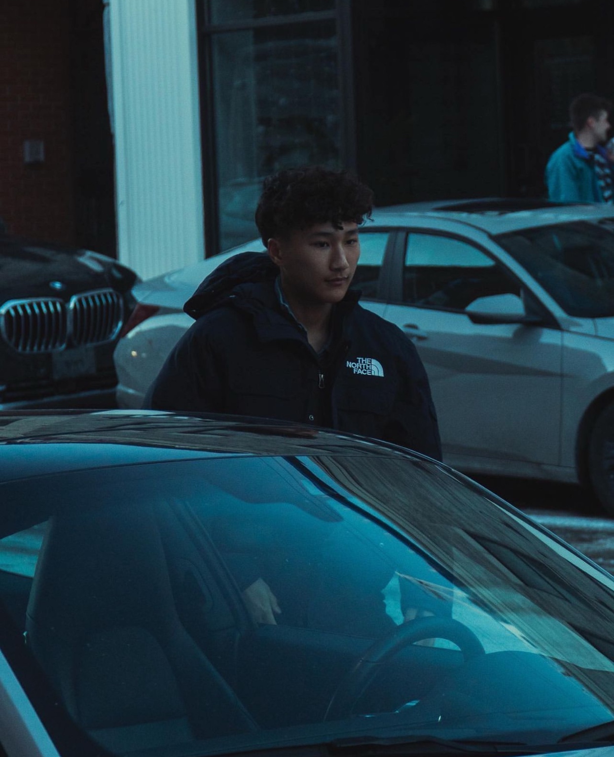 Luke Kang standing beside a car